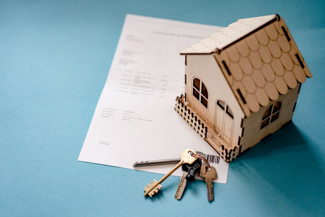 A model house and keys resting on a printed document